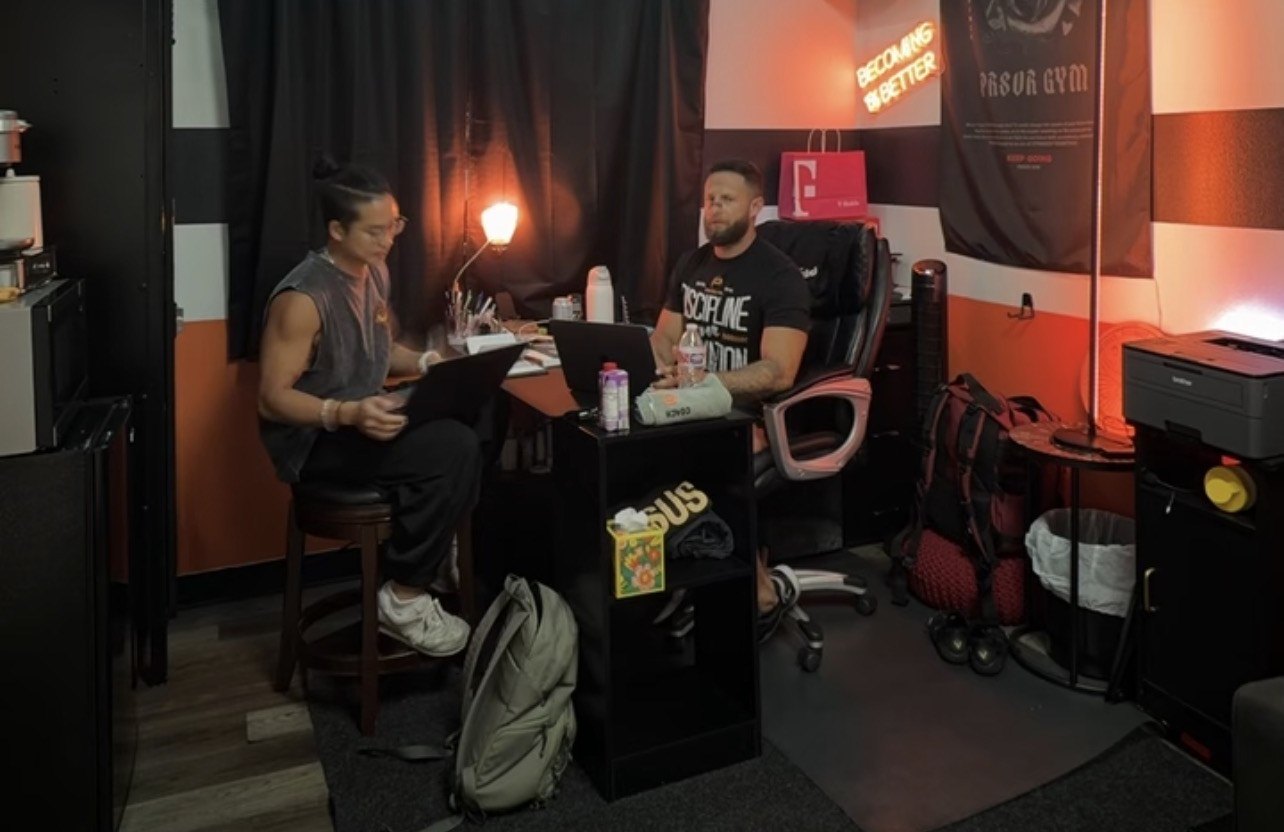 Calvin and Guillermo working on laptops in Guillermo's gym office